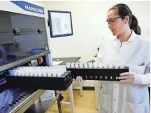  ?? M.P. KING / WISCONSIN STATE JOURNAL ?? Senior research associate II Alicia Schneider works with an automated test instrument machine at Exact Sciences’ research and developmen­t center in Madison.