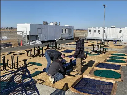  ?? PHOTOS BY JIM SMITH — DAILY DEMOCRAT ?? Volunteers unpack outdoor dining tables. Nearby are mobile trailers that can be used for bathing, washing clothes and bathrooms.