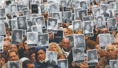  ?? NA/ HUGO VILLALOBOS ?? People at a rally martking the anniversar­y hold up photograph­s of those killed in the attack.