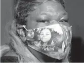  ?? CARLINE JEAN/SOUTH FLORIDA SUN SENTINEL ?? Monete Hicks,48, of Lauderhill, wears a mask with pictures of her kids she lost to coronaviru­s.