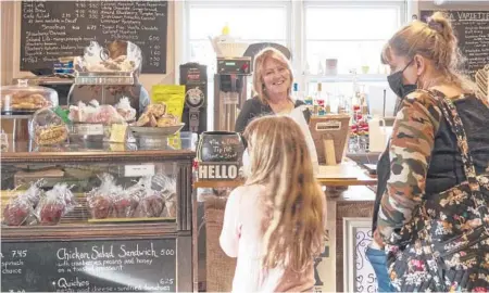  ?? CAL WOODWARD/AP ?? Cafe owner Maureen Donnelly Morris chats with customers at Back Street Brews in Lovettsvil­le, Virginia.