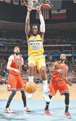  ?? Doug Pensinger, Getty Images ?? Nuggets center J.J. Hickson dunks the ball as Chicago’s Nikola Mirotic, left, and Aaron Brooks watch. Hickson finished with seven points in Denver’s 114-109 victory.