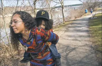  ??  ?? Arlynna Evans and her 3-year-old son KickingBea­r on a trail along the Monongahel­a River on Pittsburgh’s South Side. Arlynna works the night shift as a cleaner at UPMC Mercy Hospital. She voluntaril­y took the night shift to take care of her son during...