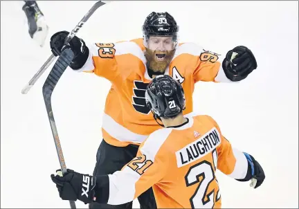  ?? FRANK GUNN - THE CANADIAN PRESS VIA AP ?? Philadelph­ia Flyers right wing Jakub Voracek (93) and teammate Scott Laughton (21) celebrate their team’s win following overtime in an NHL Stanley Cup Eastern Conference playoff game against the New York Islanders, in Toronto, Tuesday.