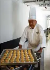  ??  ?? Chef Yip Wing-wah pushes a trolley with his freshly ovenbaked signature "spring moon mini egg custard mooncakes".