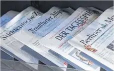  ?? FOTO: JENS KALAENE/DPA ?? Zeitungen liegen in einer Auslage in einem Zeitschrif­tenladen: Zeitungsve­rleger beklagen hohe Zustellkos­ten.