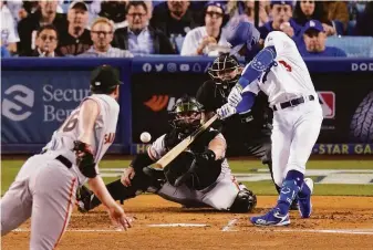  ?? Mark J. Terrill / Associated Press ?? The Dodgers’ Chris Taylor connects with a Carlos Rodón pitch for a two-run single in the second inning Tuesday night. The runners who scored both reached via a walk.