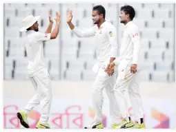  ??  ?? Bangladesh’s Sakib Al Hasan, center, celebrates with his teammates Sabbir Rahman, right, after the dismissal of Australia’s Glenn Maxwell during the second day of their first Test cricket in Dhaka Monday. (AP)