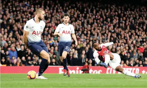  ?? | REUTERS ?? ALEXANDRE LACAZETTE, right, scores Arsenal’s third goal during yesterday’s north London derby against Tottenham Hotspur at the Emirates Stadium.