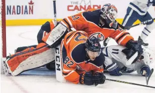  ?? JASON FRANSON THE CANADIAN PRESS FILE PHOTO ?? After jousting with the Maple Leafs’ Zach Hyman for much of the night, Oilers goalie Mike Smith gave him a shot with the blocker beside a sprawling Caleb Jones in Wednesday night’s game.