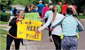  ?? NATE BILLINGS, THE OKLAHOMAN]
[PHOTO BY ?? Tammy Streeter, left, cheers the runners Sunday at NW 14 and Shartel Avenue.