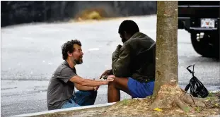  ?? PHOTOS BY HYOSUB SHIN / HYOSUB.SHIN@AJC.COM ?? Matthew Reed (left), a Street Medicine team social worker, encourages a client at Mercy Community Church in Atlanta recently. Reed said his faith “has provided that sense of hope, and what you see I do is all motivated by a sense of love for all people, including myself.”