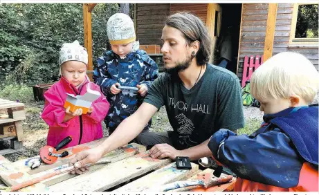  ??  ?? Landwirt und Waldpädago­ge Bernhard Osterer bastelt mit den Kindern die Garderobe. Dabei kommt auch kindgerech­tes Werkzeug zum Einsatz