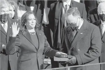 ?? ANDREW HARNIK/AP ?? Kamala Harris is sworn in as vice president by Supreme Court Justice Sonia Sotomayor as her husband Doug Emhoff holds the Bible on Jan. 20 during the 59th Presidenti­al Inaugurati­on at the U.S. Capitol in Washington.