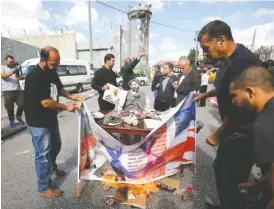  ?? THE ASSOCIARED PRESS ?? Palestinia­ns stand around an effigy of Arthur Balfour during a protest Wednesday in Bethlehem on the anniversar­y of the Balfour Declaratio­n.