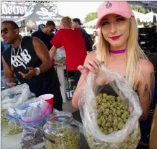  ?? AP PHOTO/RICHARD VOGEL ?? In this April 21 file photo a bud tender offers attendees the latest products of cannabis at the High Times 420 SoCal Cannabis Cup in San Bernardino.