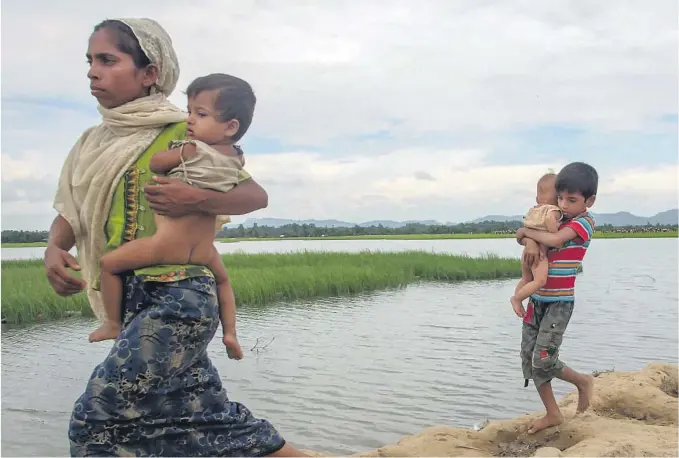  ?? BEGGE FOTO: AP/NTB SCANPIX ?? STORT ANSVAR FOR LITEN GUTT:
Rohingya-gutten Mohammad Riyaz baerer sin lillesøste­r Asma Bibi fram til flyktningl­eiren Palong Khali, Bangladesh sist torsdag.