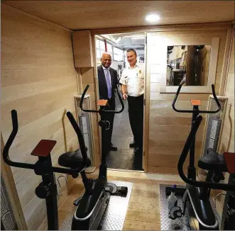  ?? BILL LACKEY / STAFF ?? Devesh Kamal (left), from Clark Schaefer Hackett, and Springfiel­d Fire Chief Brian Miller look over the inside of the new sauna the fire division received.