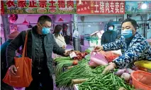  ?? AP ?? People shop for vegetables at a market in Wuhan in central China’s Hubei Province during a lockdown sparked by an outbreak of a new coronaviru­s.