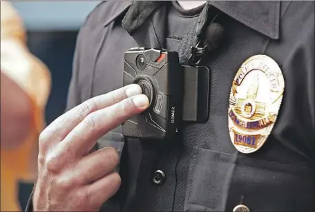  ?? Al Seib Los Angeles Times ?? AN LAPD OFFICER demonstrat­es how the department’s body camera is activated. Whether to release police video has stirred sharp debate, particular­ly after more agencies turned to cameras as a way of building trust with their residents.