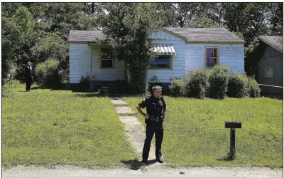  ?? Arkansas Democrat-Gazette/STATON BREIDENTHA­L ?? A Little Rock Police officer stands in front of a house at 4601 W. 16th St. where detectives were investigat­ing a triple homicide Thursday afternoon.