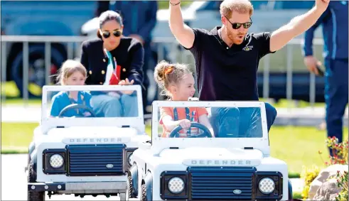  ?? ?? FOUR by 4x4: Harry and Meghan are driven by Scarlett Vroegop and Mya Poirot in mini Land Rovers yesterday