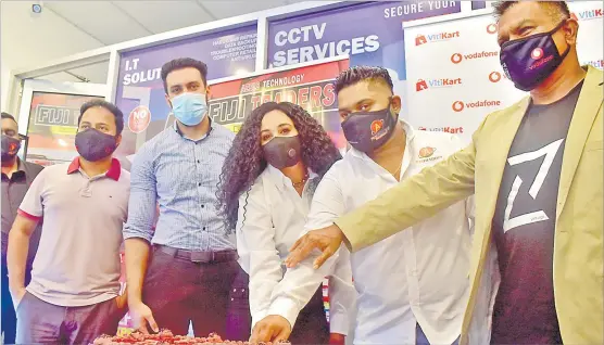  ?? Picture: ELIKI NUKUTABU ?? Vodafone’s Shailendra Prasad (far right) joins, from right, Fiji Traders director Azel Raj, Prish Raj, Haafiq Buksh and Jayesh Sali of VitiKart, to cut the cake marking the opening of their shop in Suva.