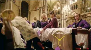  ??  ?? Choristers Chloe Chawner (centre) and Abby Cox (centre left), get ready as the first allfemale choir at the cathedral rehearses prior to their debut.