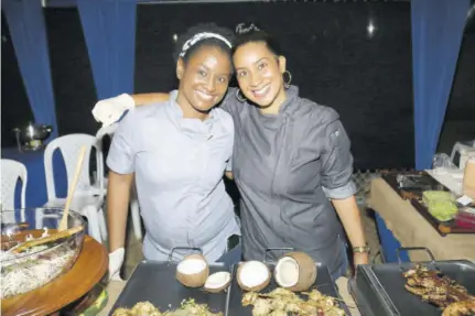  ?? (Photos: Jason Tulloch) ?? Chef Trevanne Donegal (right) with the help of fellow Le Cordon Bleu alumna Anita Chin kept Ackee guests satiated with coconut-crusted seafood-stuffed calamari and coffee-bbq chicken skewers.