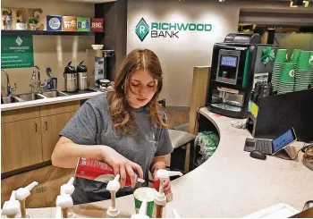  ?? BILL LACKEY / STAFF ?? Olivia Henze makes a coffee drink at the Richwood Coffee shop inside the Richwood Bank, 2454 N. Limestone St. in Springfiel­d, last week. The specialty drinks at Richwood Coffee are purchased with credits earned through donations to local nonprofits .