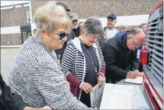  ?? KATHY JOHNSON PHOTO ?? People sign their name to show their concern for health care services in rural Nova Scotia in the pages of a book at the Save Our Rural Healthcare Provincial Day of Action rally in Shelburne on Oct. 13.