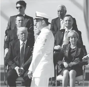  ?? EMMANUEL DUNAND / AFP / GETTY IMAGES ?? U.S. President Donald Trump and British Prime Minister Theresa May, front row, watch the military parade during the opening ceremony of the NATO summit on Thursday, where he refused to reaffirm the U.S. commitment to NATO’s Article 5.