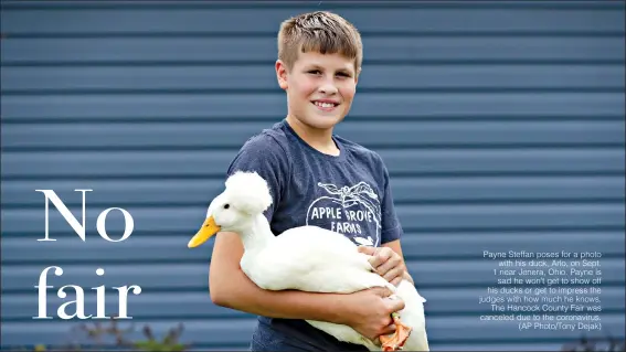  ??  ?? Payne Steffan poses for a photo with his duck, Arlo, on Sept. 1 near Jenera, Ohio. Payne is sad he won’t get to show off his ducks or get to impress the judges with how much he knows. The Hancock County Fair was canceled due to the coronaviru­s. (AP Photo/Tony Dejak)