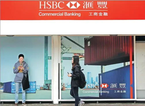  ?? REUTERS ?? Passengers wait at a tram station outside HSBC headquarte­rs in Hong Kong.