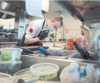  ?? JONATHAN HAYWARD THE CANADIAN PRESS ?? Brooke Blake works in the Joey Restaurant’s ghost kitchen in Surrey, B.C. Ghost kitchens have helped create jobs for staff facing layoffs due to the pandemic.