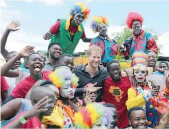  ??  ?? Youths pose for a photograph with Britain’s Prince Harry during his visit to Circus Zambia in Lusaka. — Reuters