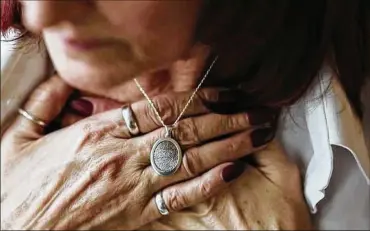  ?? JOSHUA A. BICKEL / THE COLUMBUS DISPATCH ?? Christine Allison holds a necklace bearing the thumbprint of her deceased husband, Troy. Troy’s death certificat­e says he died of a cardiopulm­onary episode, but Christine sees it as murder.