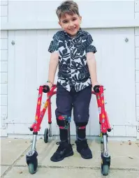 ??  ?? WALKING TALL: Harry Ragless has raised £2,400 with the help of his father and his walking frame and leg supports.