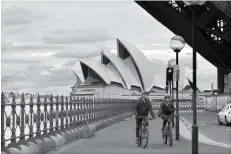  ?? SAEED KHAN/AFP ?? BATASI AKTIVITAS: Pengendara bersepeda di sepanjang jalan yang lengang di bawah Harbour Bridge di Sydney, kemarin (19/7).