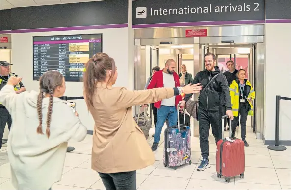  ?? ?? REUNION: Brian Glendinnin­g with his wife and daughters after arriving at Edinburgh Airport following his release after two months in an Iraqi jail.