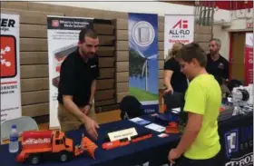  ?? BILL DEBUS — THE NEWS-HERALD ?? Winter Equipment Co. Engineer Stephen Hostetler, left, discusses products manufactur­ed by the Willoughby business with Madison High School freshman Anthony Kovacic. Winter Equipment was one of nearly 40 companies to staff booths during the sixth annual Think Manufactur­ing Career Expo, held Oct. 4 at Mentor High School. Anthony was among nearly 600 students who attended the event.