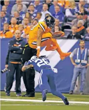  ?? DARRON CUMMINGS/THE ASSOCIATED PRESS ?? Broncos running back Devontae Booker leaps over Colts free safety Clayton Geathers on Thursday in the first half of Denver’s 25-13 win in Indianapol­is. Booker’s touchdown play was negated by a holding penalty, but the Broncos scored five plays later.