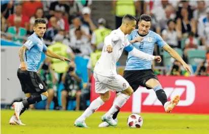  ?? THE ASSOCIATED PRESS ?? Uruguay’s Jose Gimenez, right, closes in on Portugal’s Cristiano Ronaldo during a knockout match at the World Cup on Saturday in Sochi, Russia. Ronaldo was held scoreless as Edinson Cavani scored twice in Uruguay’s 2-1 victory.