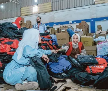  ?? Courtesy of Save the Children ?? Save the Children staff prepare supplies in Egypt before a truck carries them through the Rafah Border Crossing for children and families in Gaza in 2023.