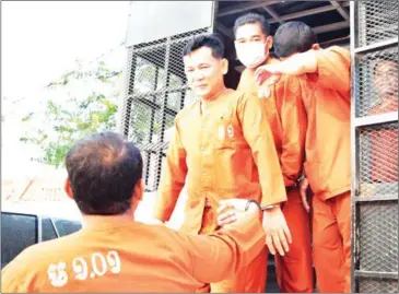  ?? HONG MENEA ?? Seang Chet (centre) arrives at the Phnom Penh Municipal Court yesterday. The opposition commune chief was sentenced to five years in prison for bribing a witness.