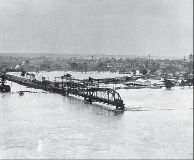  ?? Democrat-Gazette file photo ?? Part of the Baring Cross Bridge between North Little Rock and Little Rock was swept away on April 21, 1927, along with 15 freight cars loaded with coal, which had been positioned in hopes that the extra weight would steady the bridge as the swollen...