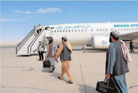  ?? // EFE ?? Un grupo de pasajeros embarcan en un avión en Kandahar tras la reanudació­n de los vuelos internos en el país