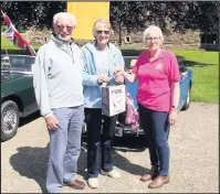  ??  ?? Helen Readwin of North Leicester MG Club (right) presents Ken and Silvia Paul, of Kent, with an award for travelling the furthest (190 miles) to take part.