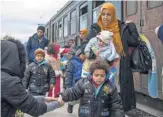  ??  ?? Migrants board a train after crossing the Macedonian- Greek border near Gevgelija on Sunday. They are heading to the European Union after fleeing Syria, Afghanista­n and Iraq.