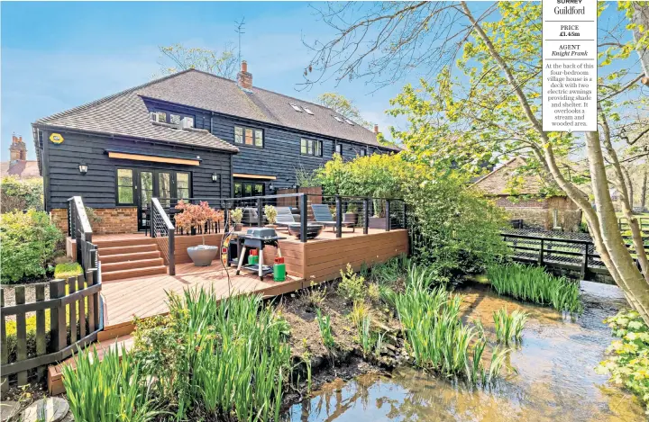  ??  ?? SURREY Guildford
PRICE £1.45m
AGENT Knight Frank
At the back of this four-bedroom village house is a deck with two electric awnings providing shade and shelter. It overlooks a stream and wooded area.